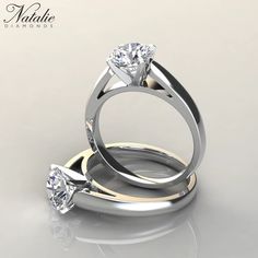 two wedding rings with one diamond on top and the other in the middle, sitting next to each other