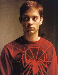 a young man wearing a spider - man t - shirt