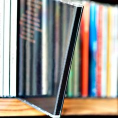 a laptop computer sitting on top of a wooden desk in front of a bookshelf