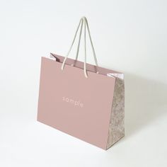 a pink shopping bag with the word sample printed on it's front and bottom