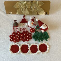 crocheted christmas ornaments are displayed on a bed next to a snowman and other holiday decorations