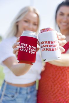 two women are holding up a gameday can coolers that say just hot, have fun