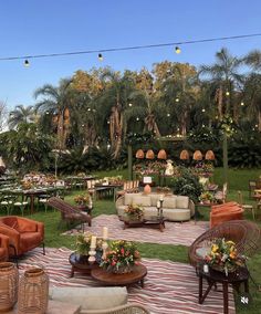 an outdoor seating area with wicker furniture and flowers in the center, surrounded by palm trees