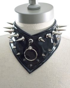 "This product is a handmade choker, created from faux leather/vegan leather. The Gorget Choker stands at 3.5\" inches in height, and it is our first choker to come to a point in the center front. All metal accessories are made of stainless steel (spikes, rivets, D-rings, chain, lobster claw). Sizes are adjustable: X Small: 12-14 inches Small: 14-16 inches Medium: 16-18 inches Large: 18-20 inches" Holographic Choker, Rings Chain, Emo Stuff, Handmade Chokers, Black And White Shirt, Emo Outfits, Punk Outfits, Metal Accessories, Choker Necklaces