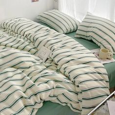 a bed with green and white striped sheets