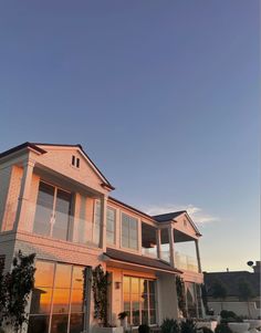 a large house with many windows on the front and side of it at sunset or dawn