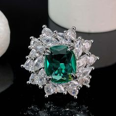 ✰Introducing our latest Paparacha Zirconia Ring featuring an emerald-cut gemstone in mesmerizing lake blue hue, encircled by white marquise and teardrop cubic zirconia. Meticulously crafted to exude charm and luxury, this stunning piece elevates your style, adding an air of elegance and sophistication to any ensemble. ✰ Crafted with precision, this eye-catching ring is made from copper and plated with 18k white gold, ensuring both durability and a luxurious shine. The adjustable design allows fo Formal Cubic Zirconia Crystal Ring For May Birthstone, Emerald Cubic Zirconia Ring With Center Stone, Dazzling Green Diamond-cut Rings, Dazzling Green Diamond Cut Ring, Green Cubic Zirconia Cluster Ring For Wedding, Green Cubic Zirconia Cluster Wedding Ring, Green Cubic Zirconia Ring With Halo Setting, Emerald Cubic Zirconia Ring With Vvs Clarity As Gift, Emerald Ring With Cubic Zirconia Center Stone For Gift