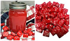 a jar filled with candy next to a pile of red candies