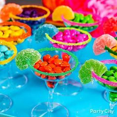 colorful candies and candy in small bowls on a blue tablecloth with text overlay that reads party city