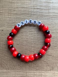 a red and black beaded bracelet with the word arrest spelled on it