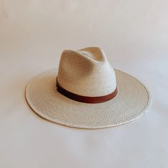 The Soleil straw fedora was thoughtfully designed to be an approachable, ready to wear style that effortlessly tops off any warm weather outfit. Featuring a flat, stiff brim size that measures 3 1/2", and a classic pinch crown fedora shape, the Soleil shines for everyday wear, offering UPF 50+ sun protection. Sustainably harvested tripilla palm straw is lightly toasted, then intricately handwoven by artisans in Puebla, Mexico to create each Soleil style, part of our premium straw hat collection. Adding to the versatility of our headwear, the Soleil's removable and interchangeable, genuine leather hatband with its gold hardware finish has become a Leah hat signature. Available with an adjustable inner, cotton sweatband for a more comfortable fit. Each hat comes with a genuine brown leather Summer Fedora With Short Brim For Everyday, Summer Style Natural Fedora For Everyday, Summer Natural Color Fedora For Everyday, Natural Summer Fedora For Everyday, Summer Fedora In Natural Color For Everyday, Summer Fedora With Curved Brim For Everyday, Casual Flat Brim Straw Hat, Casual Straw Hat With Flat Brim, Casual Straw Hat With Flat Brim For Everyday