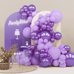 purple balloons are on display in front of a party sign and table with vases