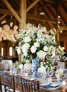 the table is set with blue and white flowers