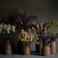 several vases with flowers in them on a table