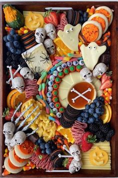 a wooden box filled with lots of halloween food and decorations on top of each other