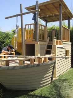 a wooden boat sitting on top of a lush green field