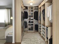 a walk in closet filled with lots of clothes and shoes on shelves next to a carpeted floor