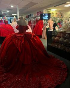 a red ball gown is on display in a store with other mannequins