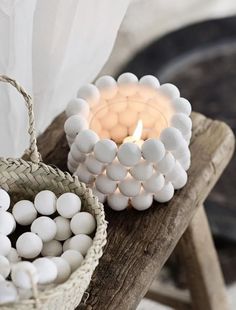 a basket filled with marshmallows next to a lit candle