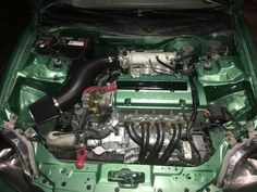 the engine compartment of a green car with its hood open