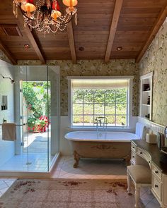 a bath room with a tub and a chandelier hanging from it's ceiling