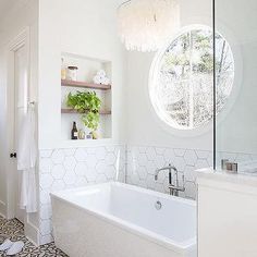 a white bath tub sitting under a round window