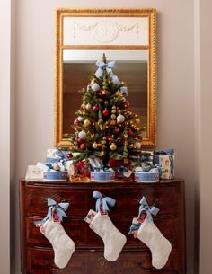 a decorated christmas tree sitting on top of a wooden dresser