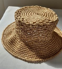 Looking for a hat to complement your style on hot summer days? This handmade raffia hat is for you! It offers a comfortable use thanks to its breathable beige raffia material. It is suitable for use both on the beach and in the city with its design in the style of a straw beach hat. This expertly crafted hat is handcrafted and crafted using sustainable materials. Express your style on your summer adventures with this comfortable, stylish and environmentally friendly hat. Natural Crochet Hat For Spring, Beige Brimmed Crochet Hat For Warm Weather, Summer Flat Brim Open Weave Hat, Summer Open Weave Hat With Flat Brim, Summer Hats With Open Weave And Flat Brim, Spring Straw Hat With Open Weave And Flat Brim, Cream Toquilla Straw Hat For Vacation, Spring Straw Sun Hat With Open Weave, Natural Wide Brim Toquilla Straw Bucket Hat