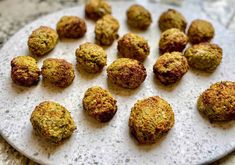 a white plate topped with meatballs on top of a table