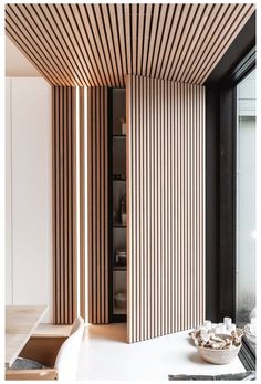 the interior of a modern home with wood slats on the walls and flooring