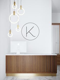 a reception table with lights hanging from it's ceiling and the letter k above it