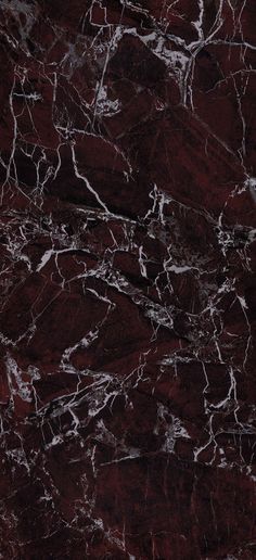 a red marble textured surface with white streaks on the top and bottom, as well as dark brown veining