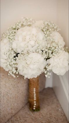 a bouquet of white flowers sitting on top of a couch