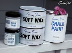 three cans of chalk paint sitting on top of a white window sill next to a pink flower