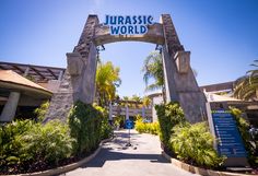 the entrance to an amusement park with a sign that says, jurasic world