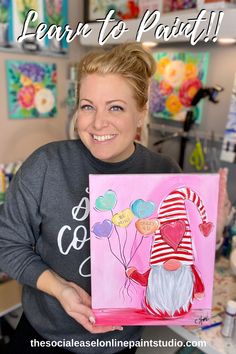 a woman holding up a painting in front of her with the words learn to paint on it