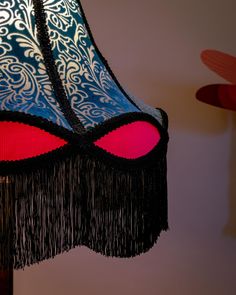 a lamp shade with fringes on it in a room