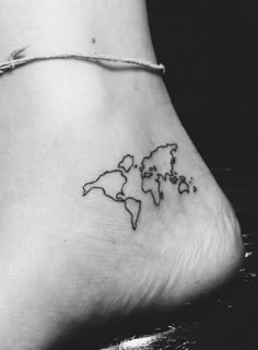 a small tattoo on the ankle of a woman's foot that reads world map