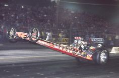 a drag car being towed by a truck at night