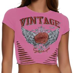 a woman wearing a pink crop top with wings and roses on it