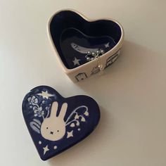 two heart shaped dishes sitting next to each other on a white counter top, one with a blue and white design