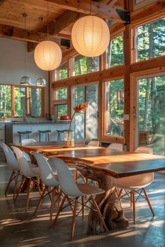 a dining room table surrounded by chairs in front of large windows with lots of natural light