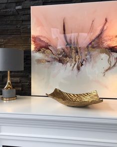 a painting on a mantle with a lamp next to it and a fireplace mantel