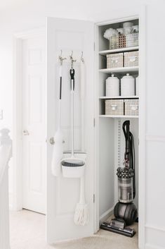 a room with white walls and shelves filled with cleaning supplies, including a vacuum cleaner