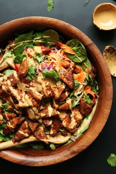 a wooden bowl filled with salad and dressing