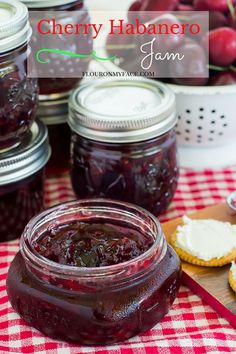 cranberry jam in a glass jar on a red and white checkered tablecloth