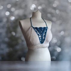 This one of a kind bralette will make you stand out wherever you go!  Featuring:  Deep V blue shell detailing! White ribbing around the waist! A criss cross back! Made in both white and turquoise 100% acrylic yarn.  Perfect for festivals with high waisted denim shorts or harem pants!  Bralette pictured is made to fit size medium and is ready to dispatch!  Full Sizing details:  Small - A-B cup  Medium - B-C cup Large - D cup  XL - DD cup Sizes vary depending on the coverage you want so if you aren't sure what size to get or want it made to your exact bra size please message me.   Items can be machine washed at 30o and laid flat for drying. All items with decorative charms or beading should be hand washed in Luke warm water and laid flat for drying. DO NOT TUMBLE DRY.  Custom orders in other Spring Festival Crop Top With Built-in Bra, White Halter Crop Top With Built-in Bra, White Halter Neck Crop Top With Built-in Bra, White Triangle Crop Top With Built-in Bra, White Crop Top With Built-in Bra And Triangle Shape, White Crop Halter Top With Built-in Bra, Festival Bra Friendly Cropped Top, Handmade White Halter Top For Vacation, Cropped Bra For Beach In Summer