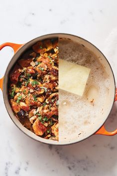 a pan filled with food sitting on top of a counter next to a spatula