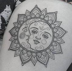 a sun tattoo on the back of a woman's thigh with an intricate design