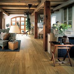 a living room filled with furniture and lots of wood flooring on top of it